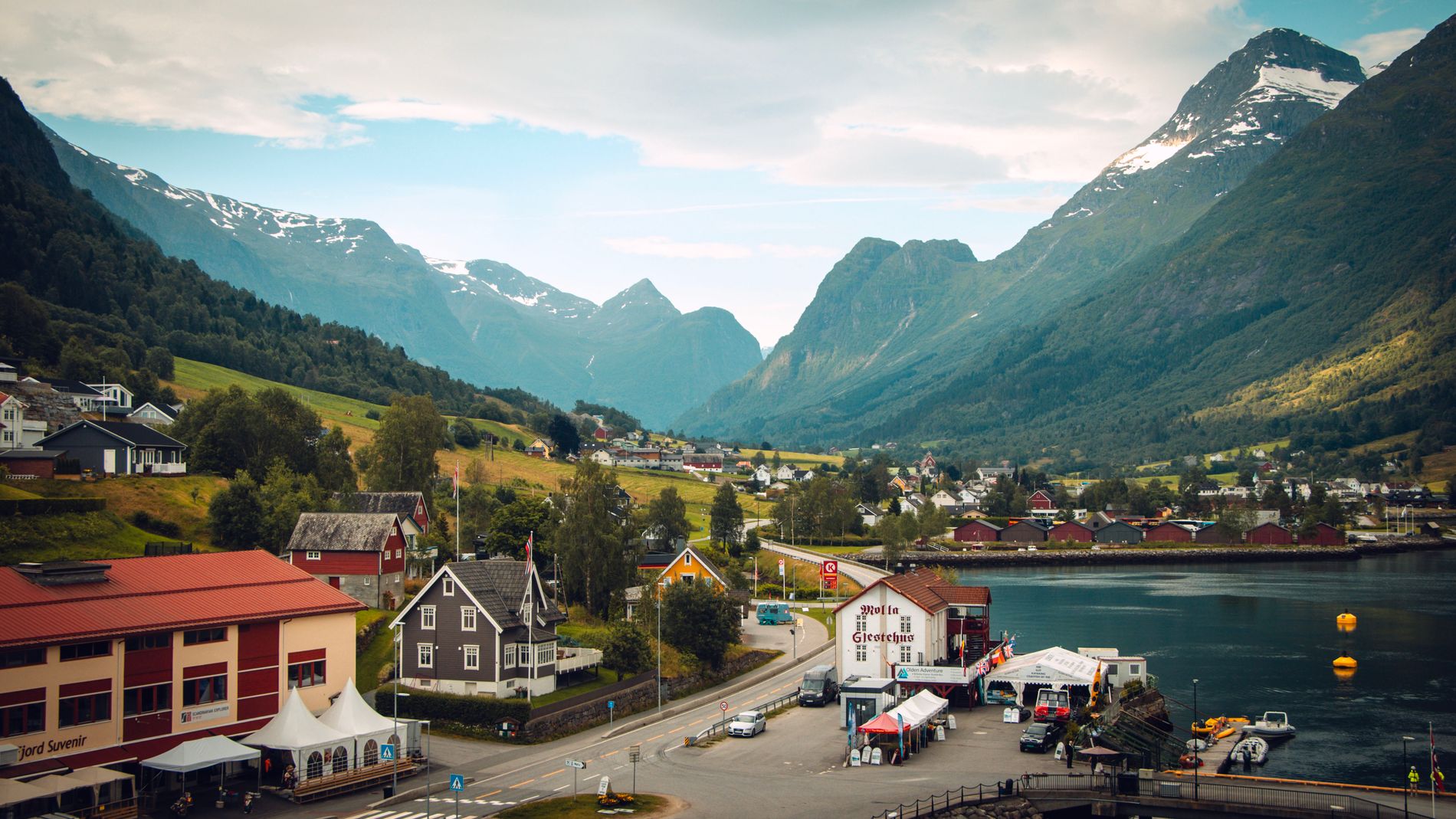 Norwegian village between green mountains and fjord waters